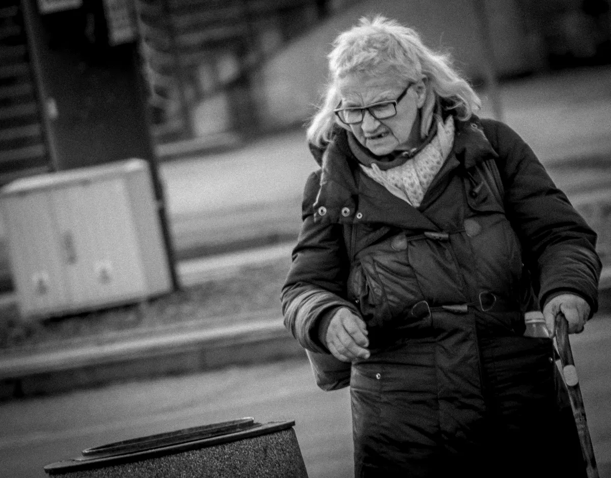 Elderly woman hurrying through the street with a handbag